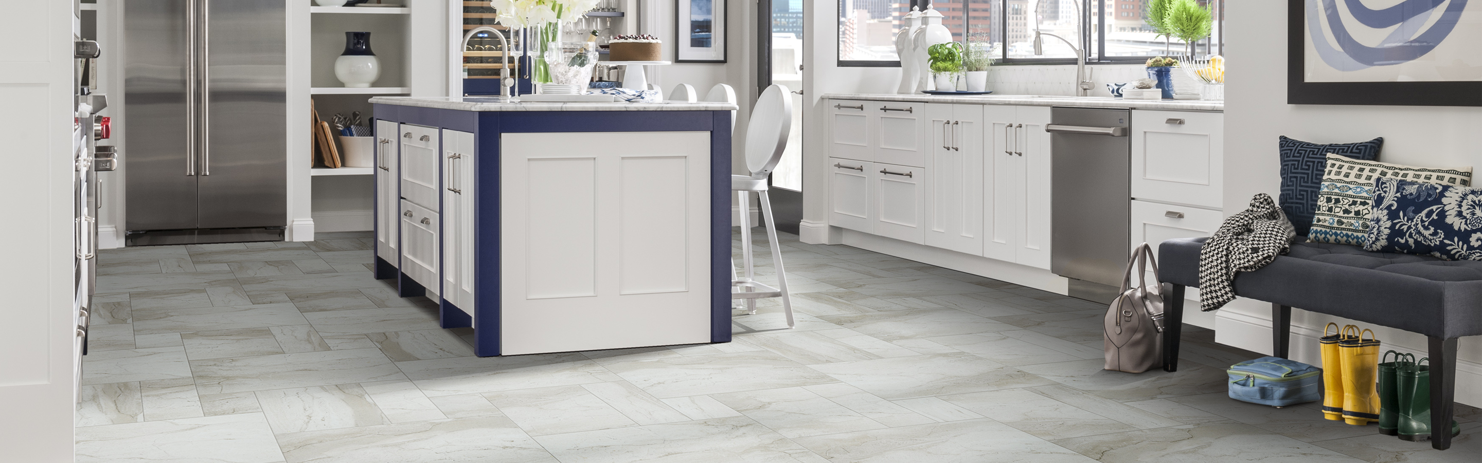 White tile floor in kitchen with island and navy accents 