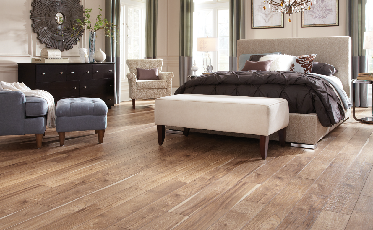 Wood Look tile planks in bedroom with grey chair and ottoman 